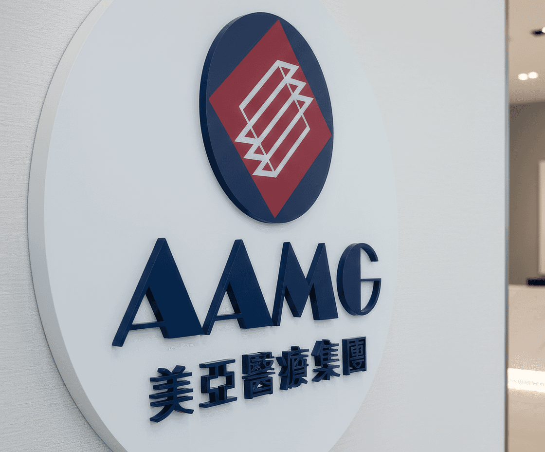 Circular lobby plaque featuring the AAMG logo with dimensional lettering and Chinese characters