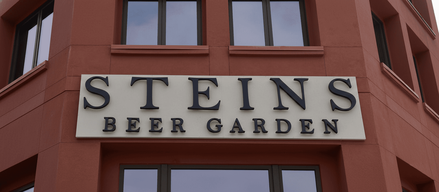 Halo-lit exterior sign for Steins Beer Garden glowing at sunset