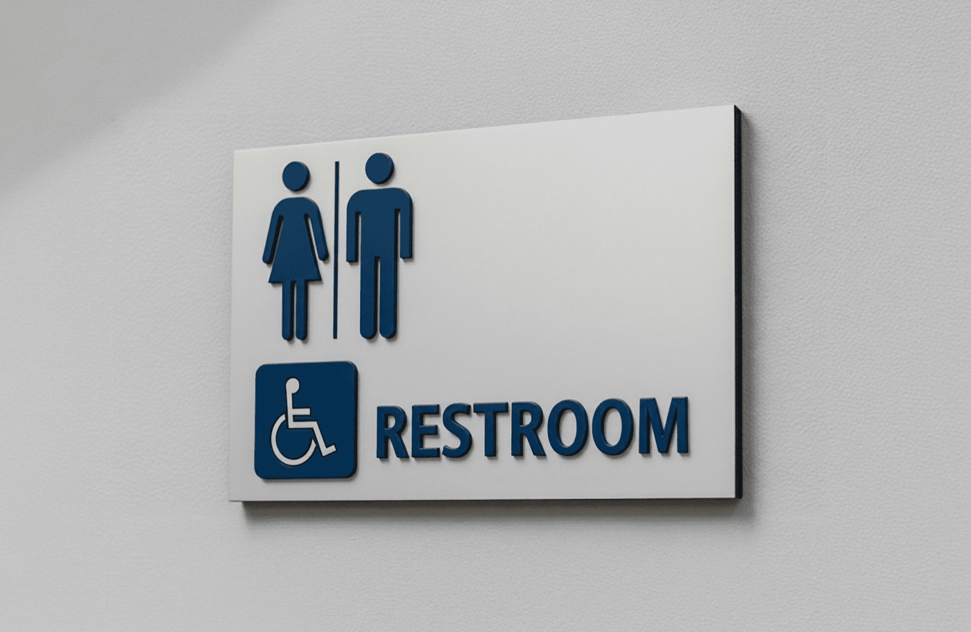 Wall-mounted restroom sign featuring raised blue symbols with dimensional lettering