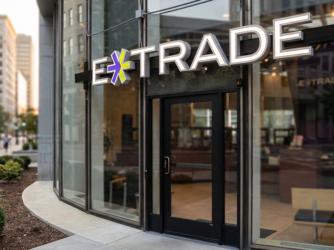 Illuminated E*TRADE storefront channel letters above a glass entrance