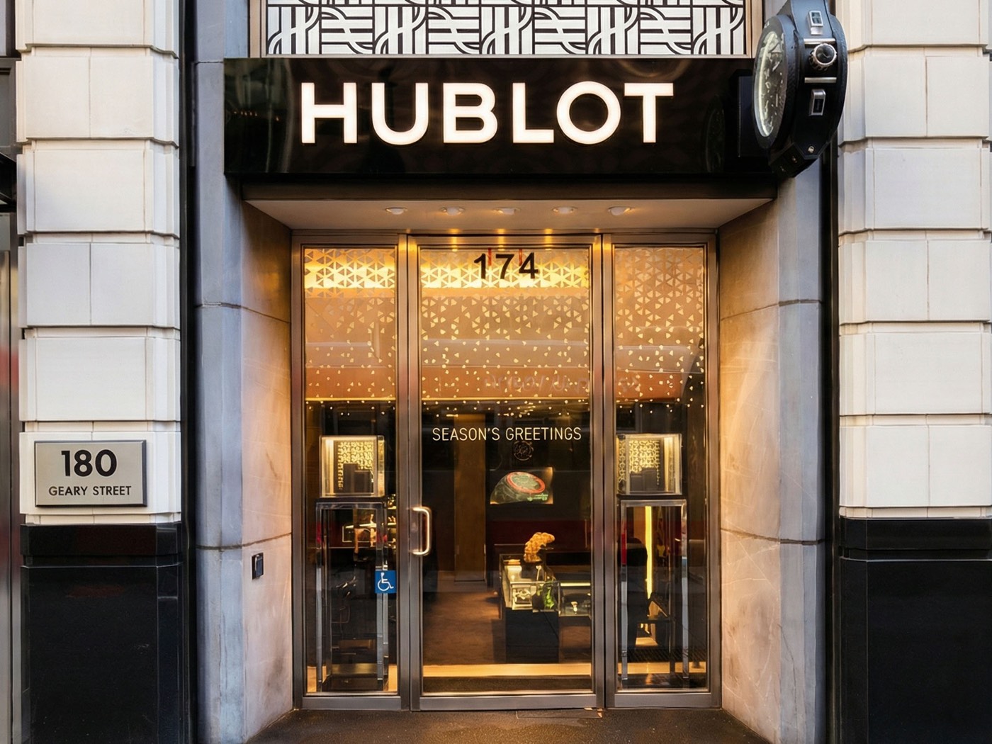 Luxury storefront sign with illuminated letters above a glass retail entrance